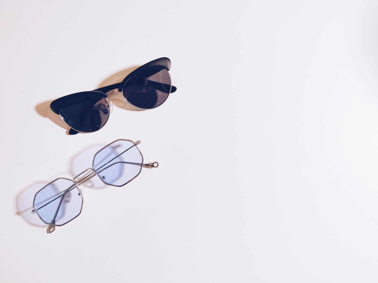 Flat lay of sunglasses and eyeglasses on a white background, perfect for fashion design concepts.